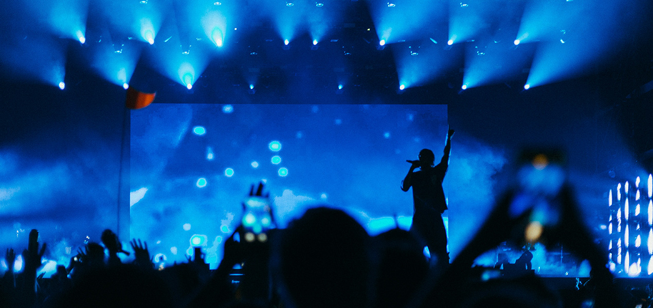 A band performing on stage in front of a large crowd.