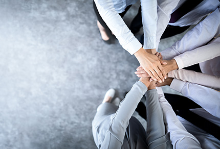 A group of people putting their hands together in a circle