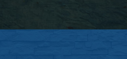A dark block on top of a blue brick wall. 