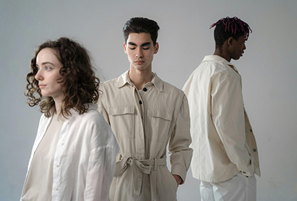 Three Gen Z professionals standing in a plain room looking in different directions.