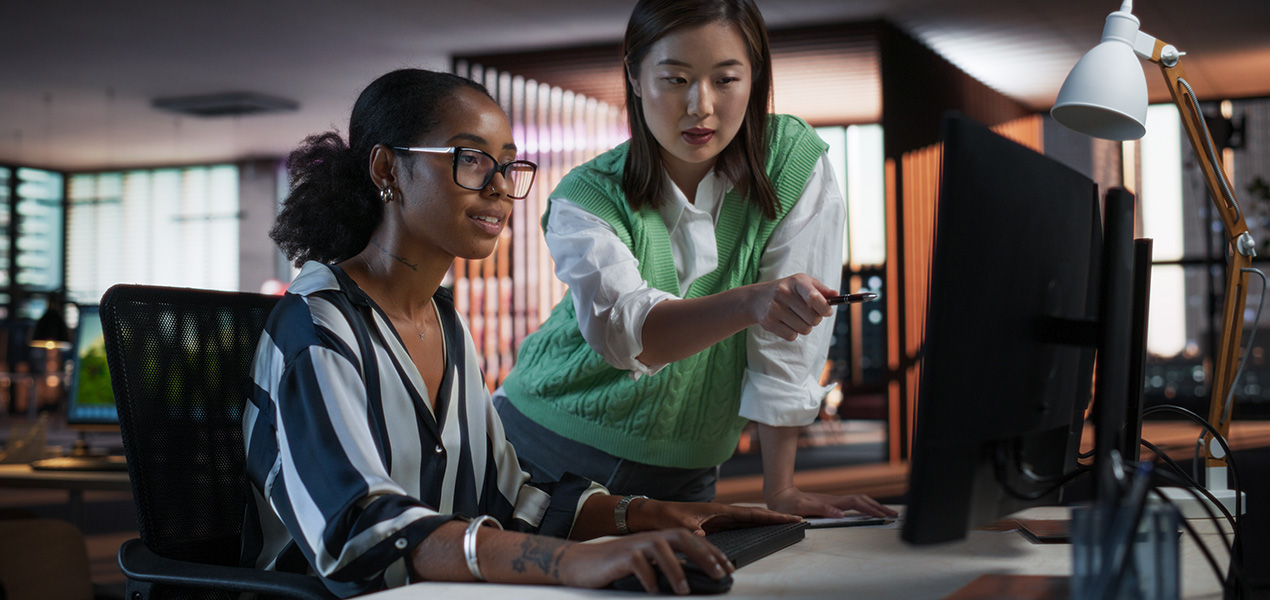 Two Stylish Diverse Women Discussing Design on Desktop Computer