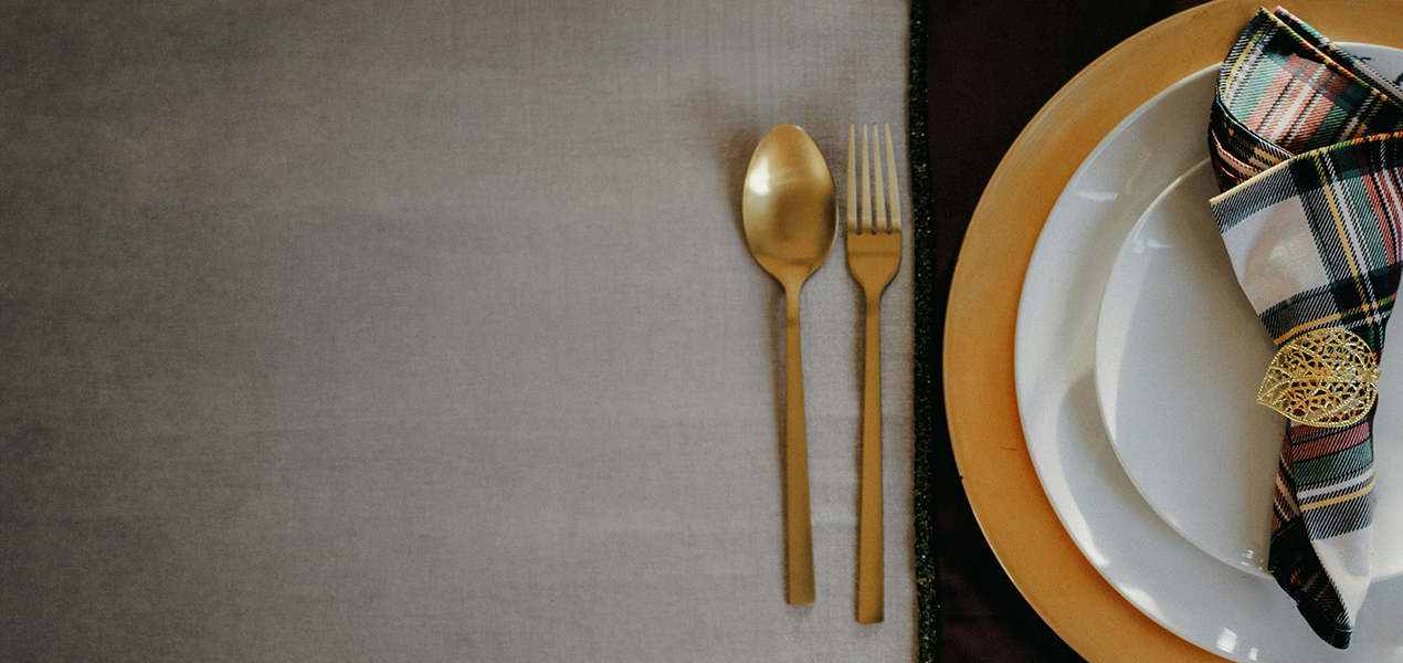 A formal place setting on a dark wood table.