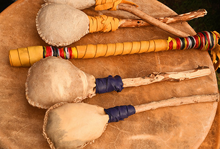 Traditional hand made Canadian West Coast Indigenous drum and drum sticks made of deer hide and wood sticks.