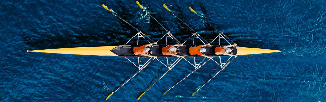 People sitting around a meeting table and looking towards a colleague at the end of the table.