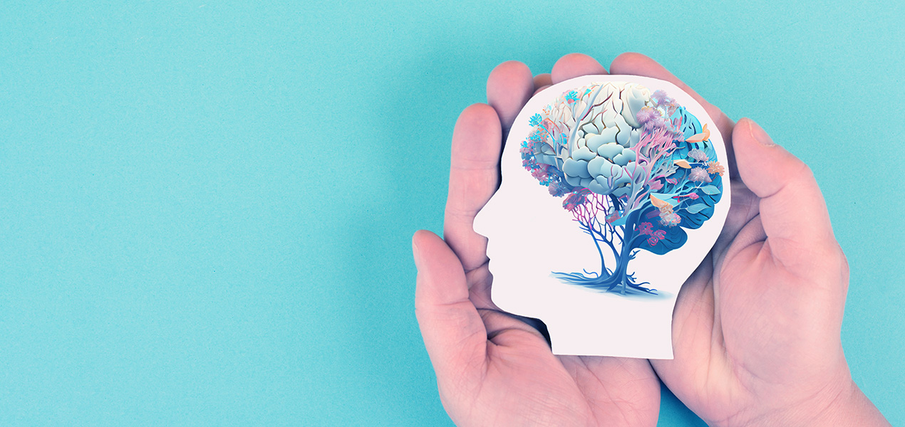 An illustration of a tree in the form of a human brain held by two hands.