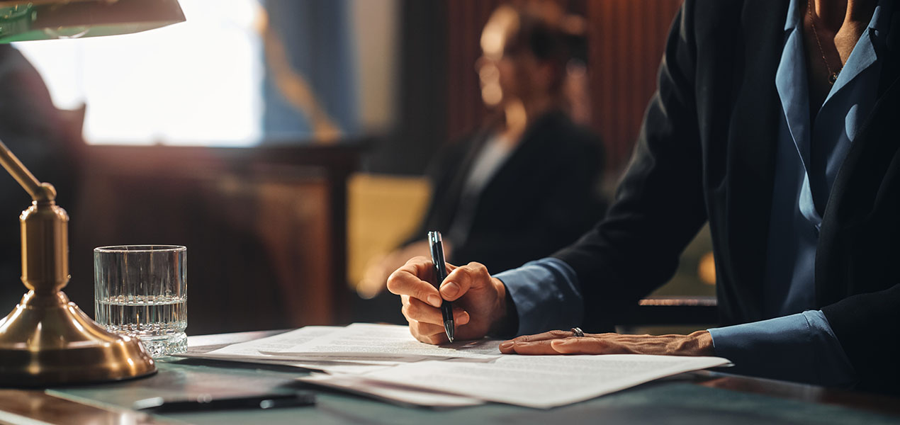 A trial attorney writes down notes in court.
