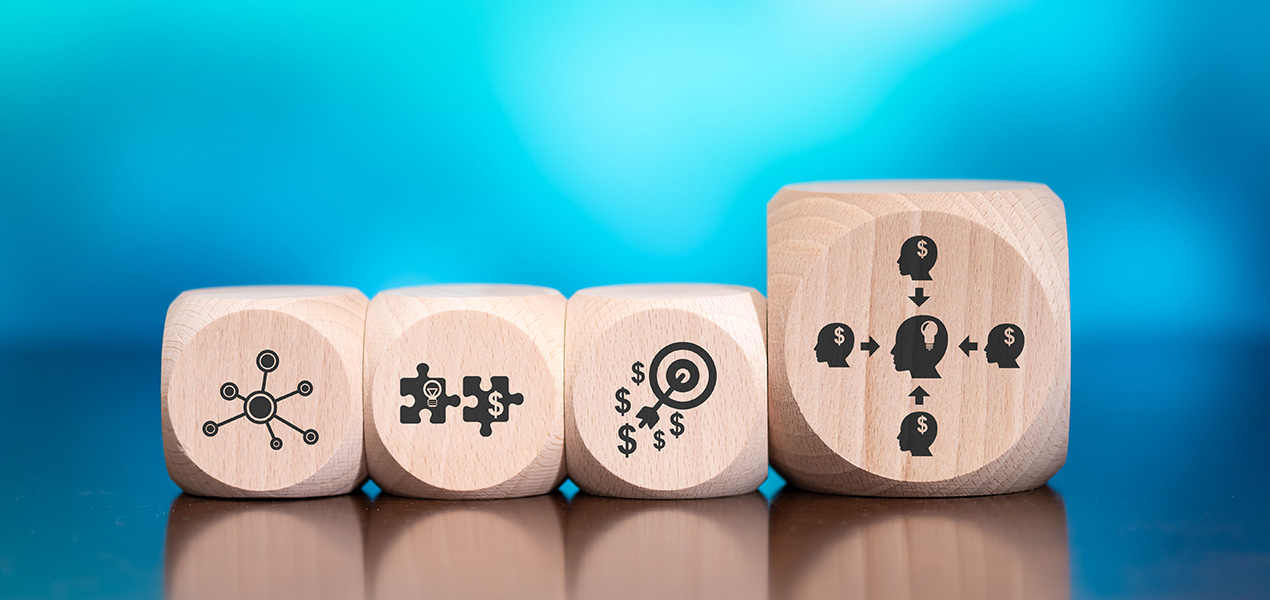 Four wood blocks in a row with illustrations depicting marketing tactics.