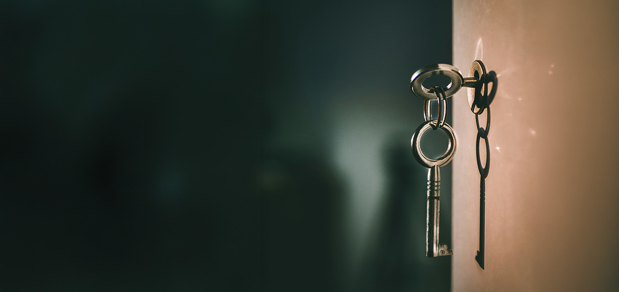Close up of an ornate key opening a lock in a door.