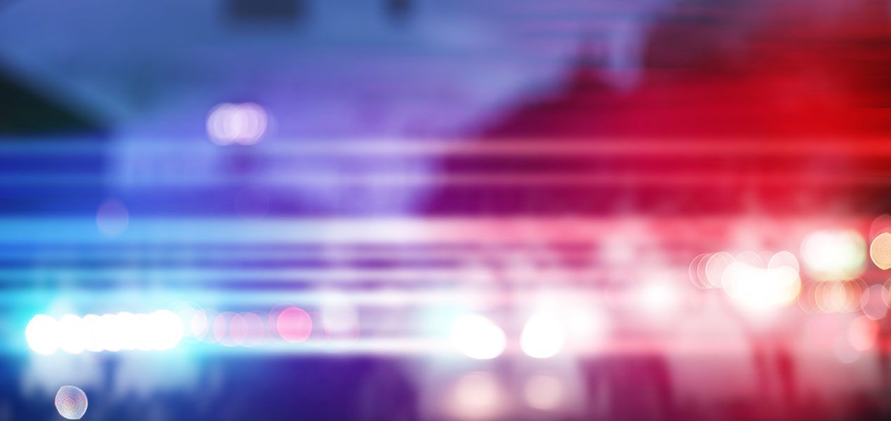 Blurred view of police cars on street at night.