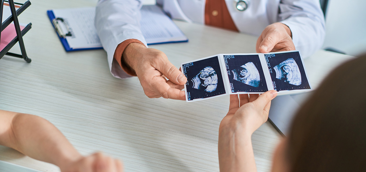 A doctor showing an expectant mother photos on an ultrasound.