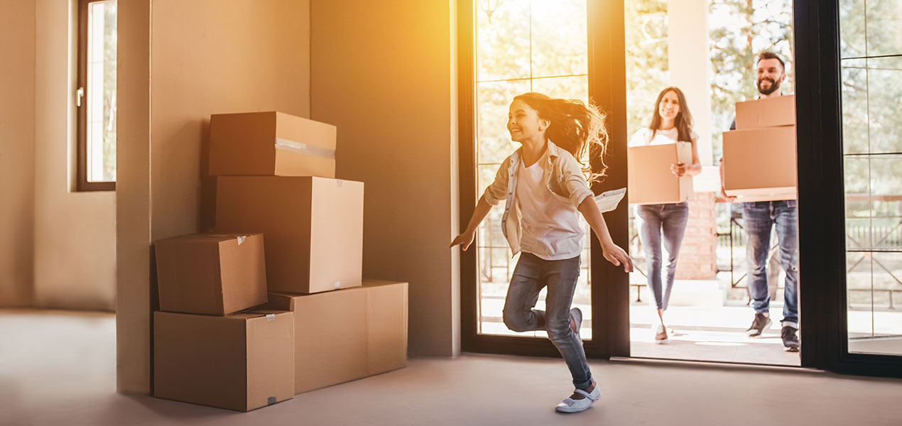 A happy family is moving boxes into their new home.