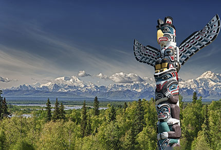 Scenic view of mountains in background and totem pole in foreground.