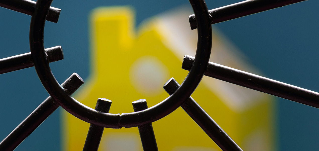 A model home with a gate in front of it. 