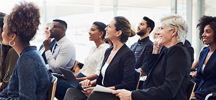 Diverse group of professionals listening to a presentation.