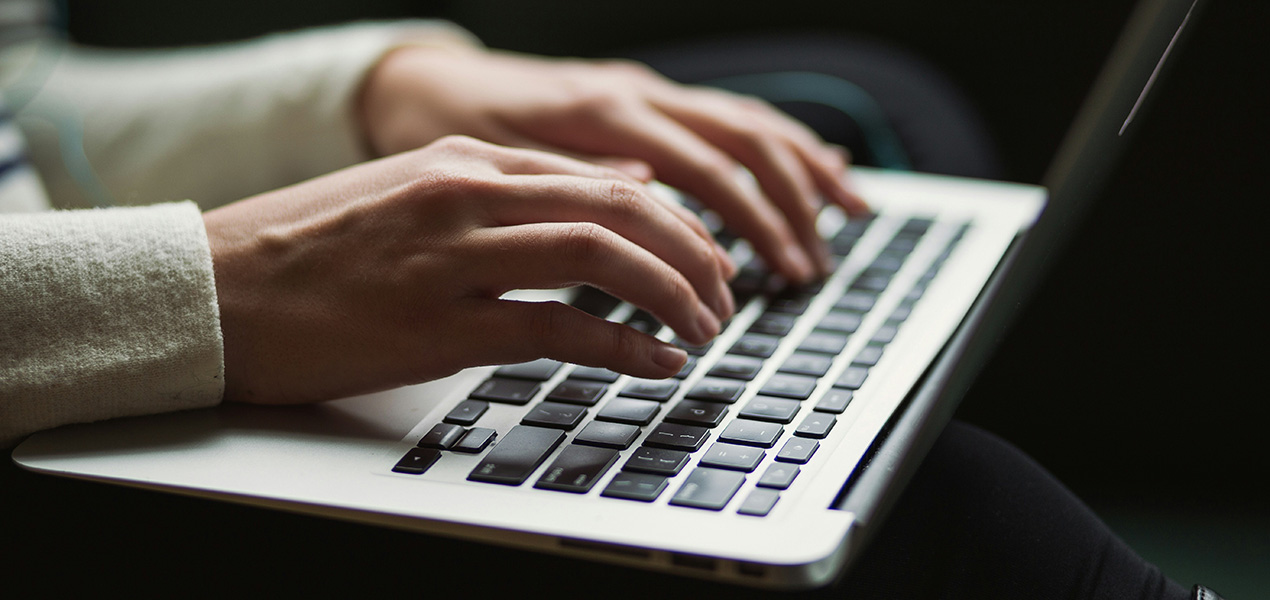 Close up of a person typing on a laptop.