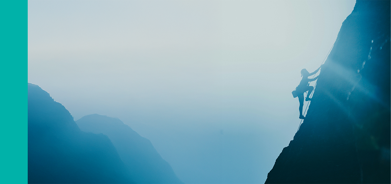 A lone rock climber scaling a steep incline.