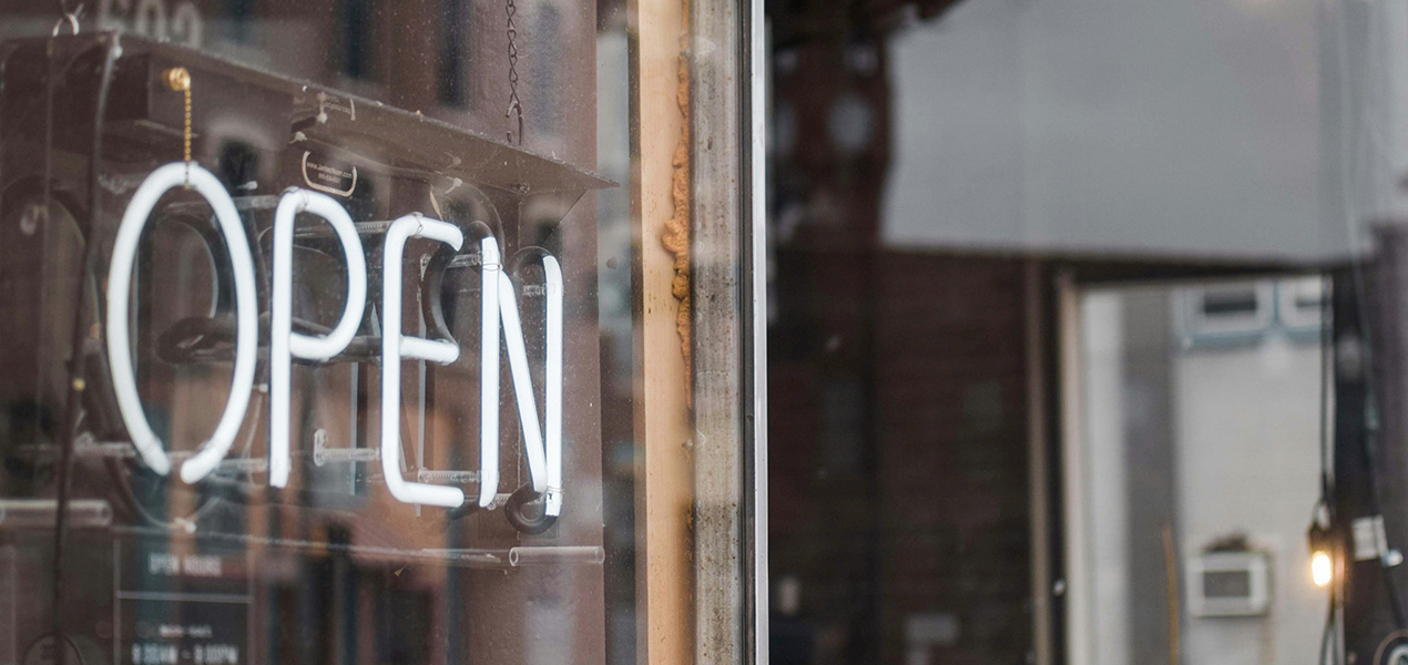A neon open sign in a storefront window.