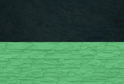 A dark block on top of a green brick wall. 