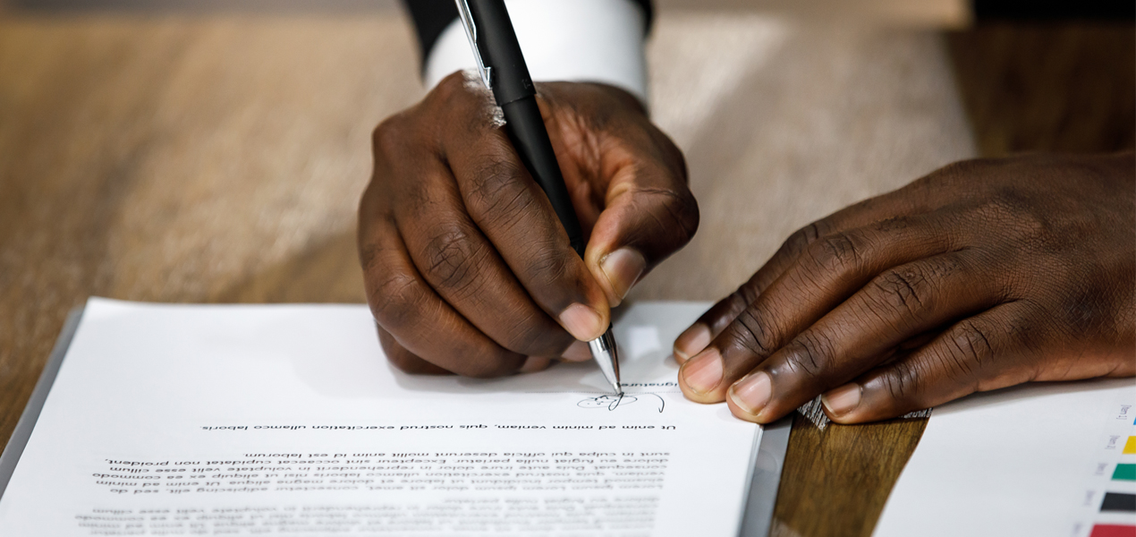 Close up of male hands signing a contract agreement.