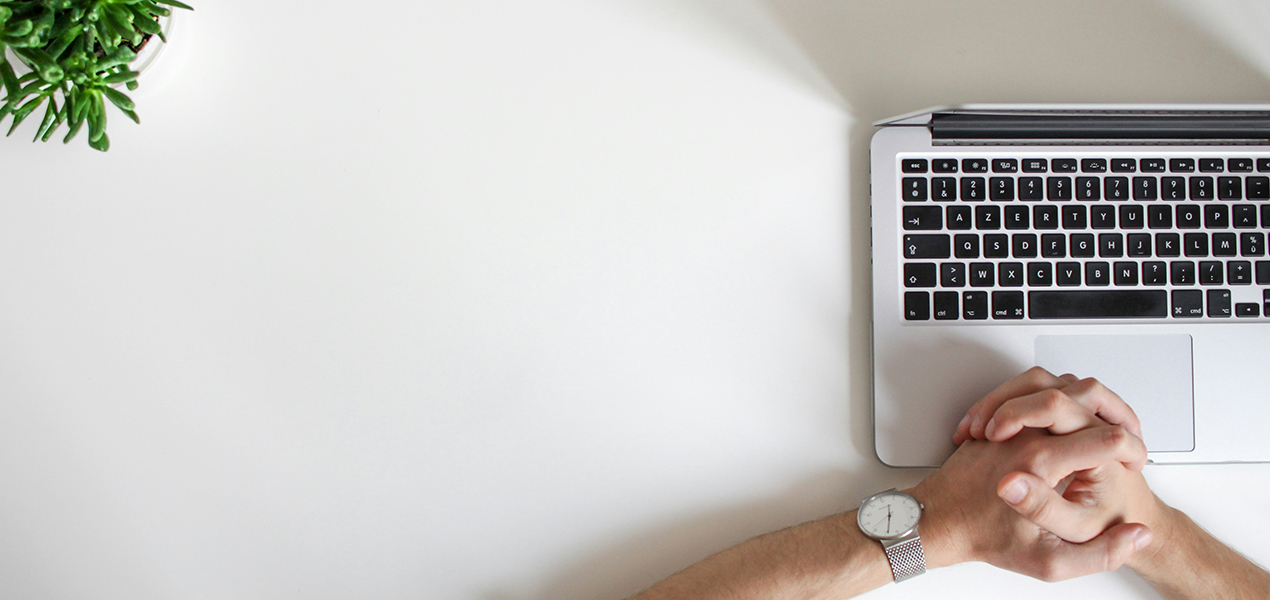 A professional sitting at a desk with an open laptop.