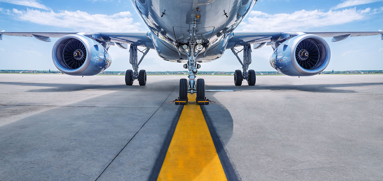 Photo facing an airplane on the runway with turbines in view.