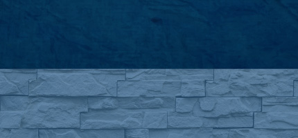 A dark block on top of a blue brick wall. 