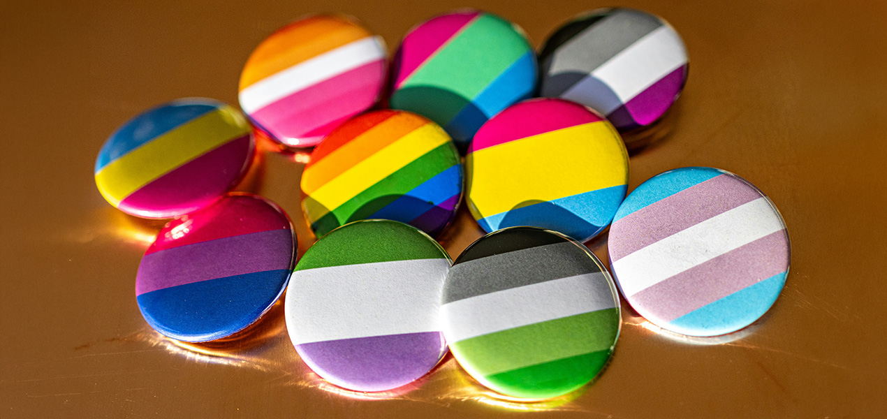 A collection of various gender and orientation flag buttons. 