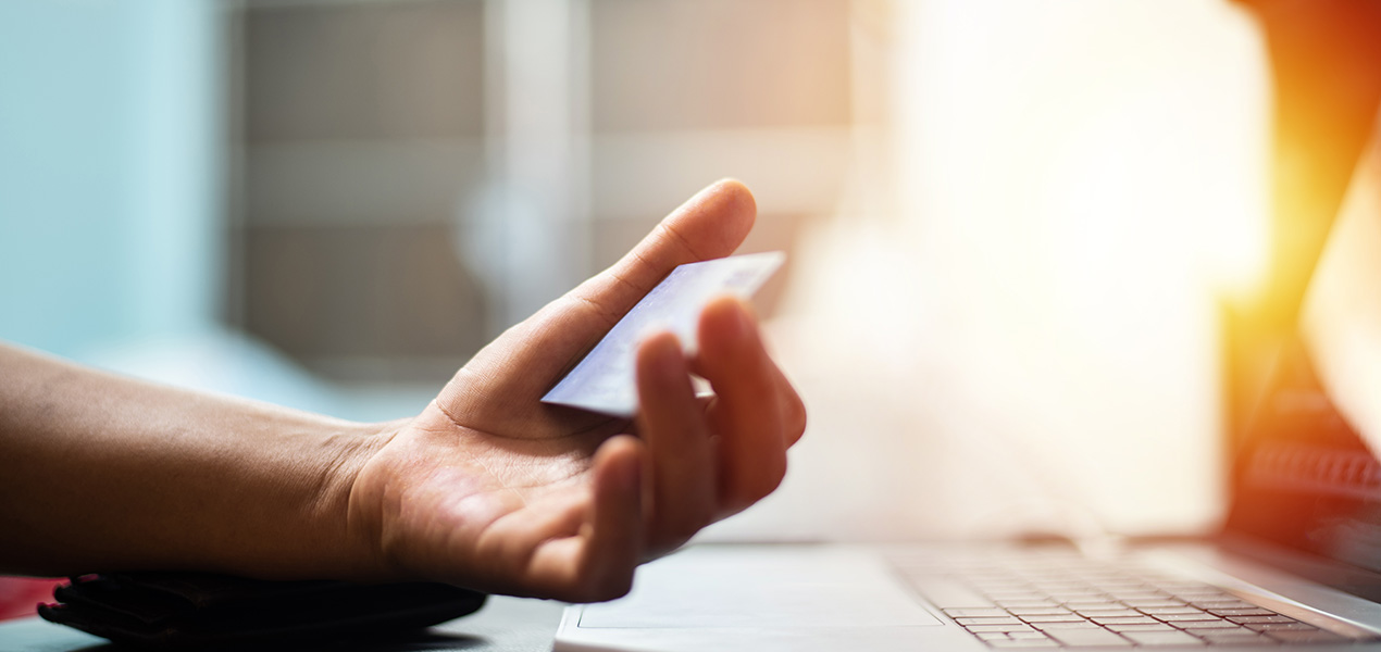 Hand with credit card with laptop in shopping online concept.