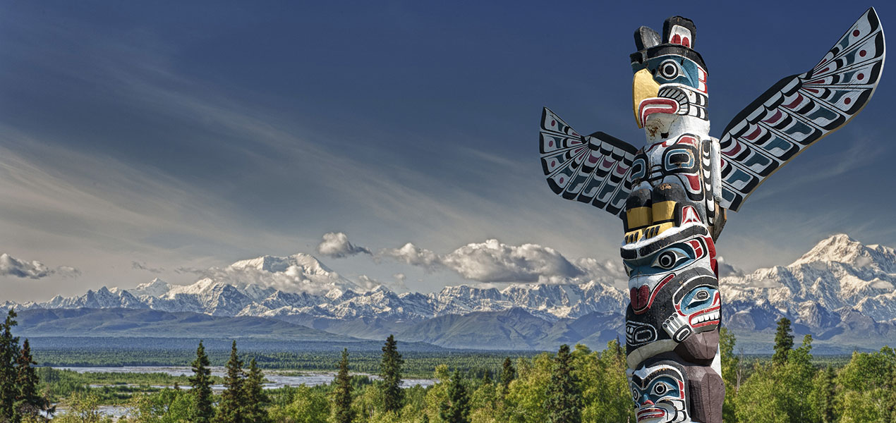 Scenic view of mountains in background and totem pole in foreground.