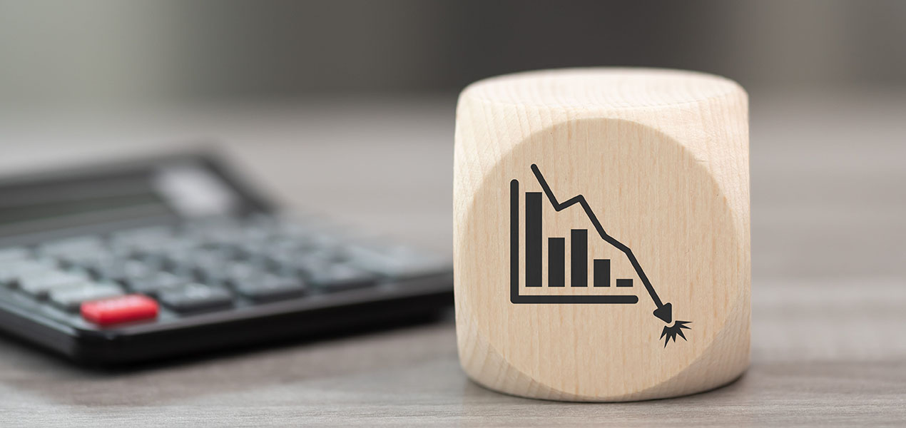 A wooden block with a bar graph and line trending downwards symbolizing bankruptcy.