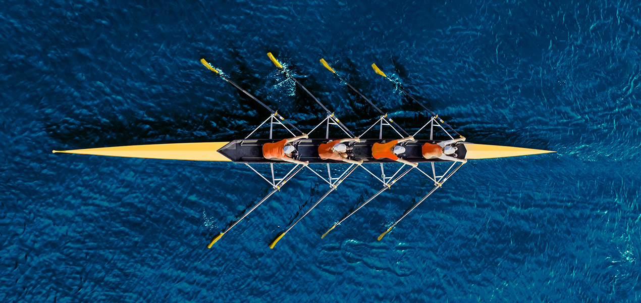 Group of four people at office meeting table, taken from above.