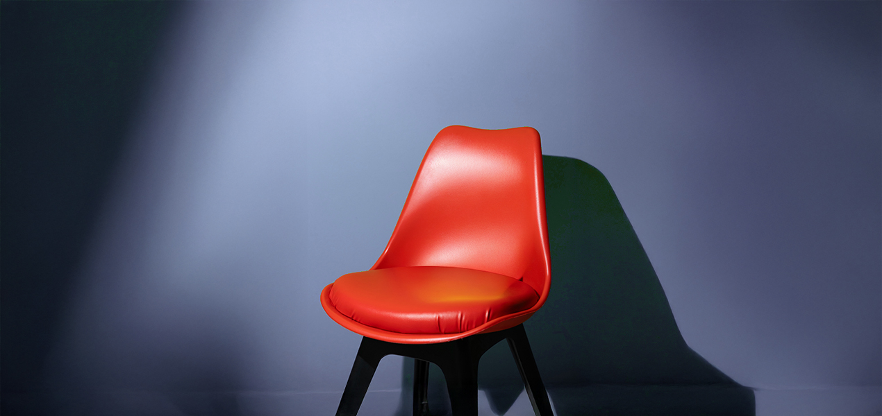 A single, empty chair with a spotlight shining on it.