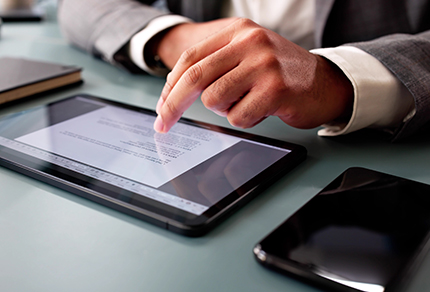 Close up of a person scrolling on an iPad.