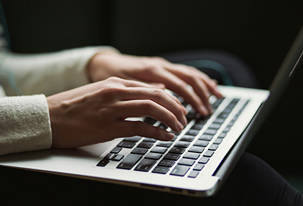 Close up of a person typing on a laptop.