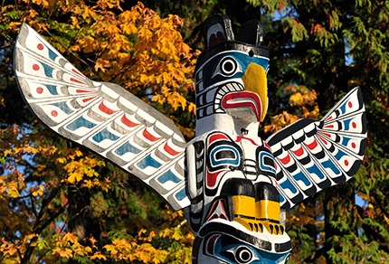A brightly painted eagle at the top of a totem pole.